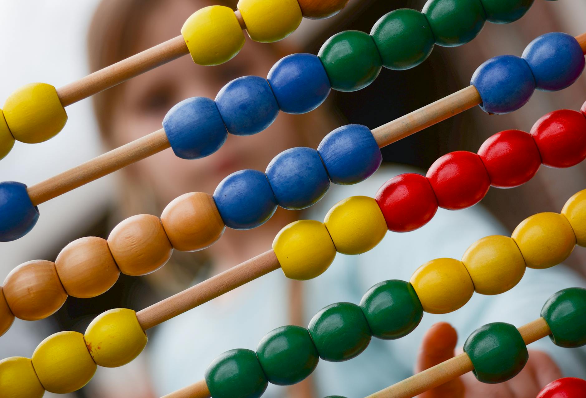 Dziecko uczy się matematyki przy kolorowym drewnianym liczydle