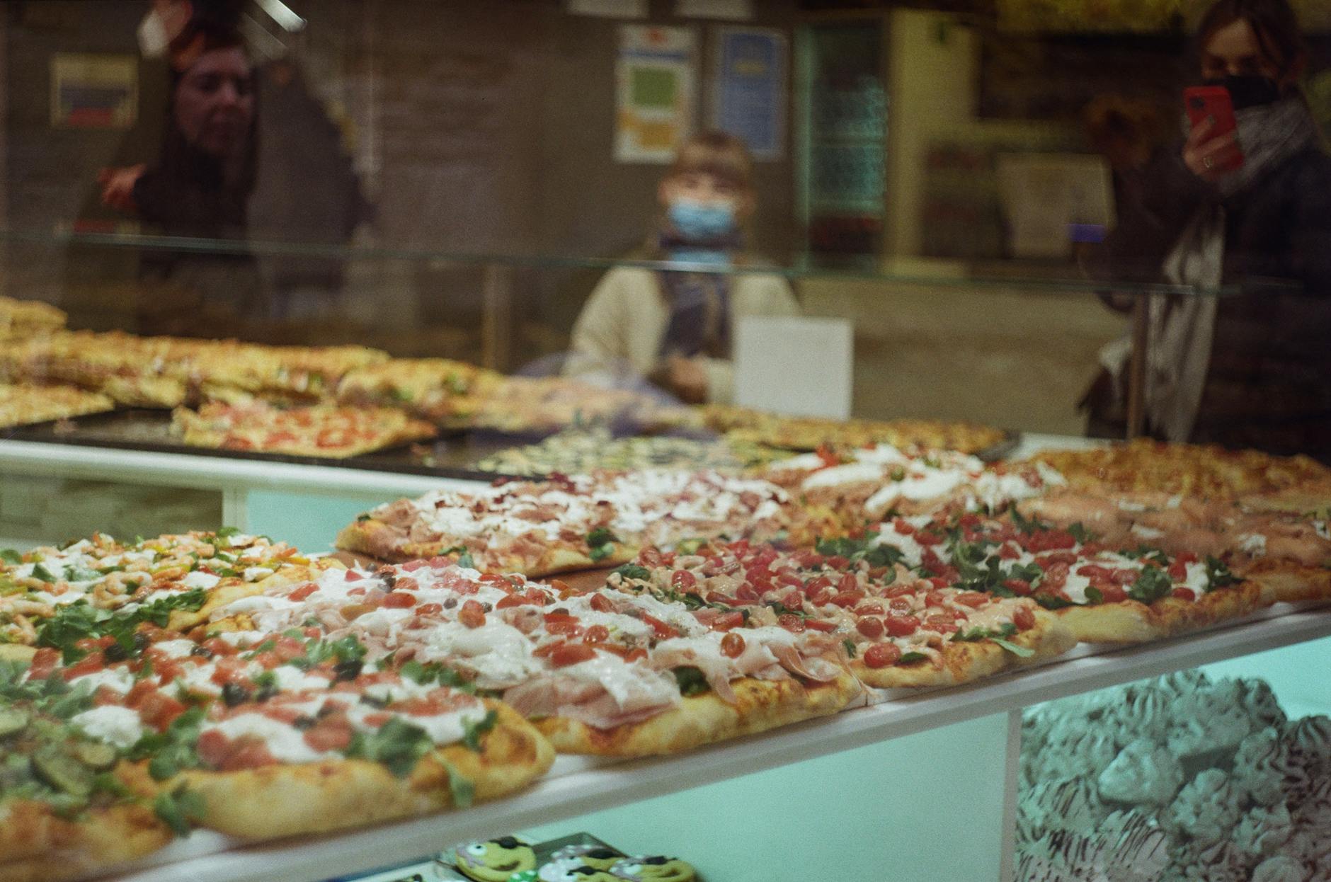 Różne rodzaje pizzy na blasze w piekarni jako przykład street foodu