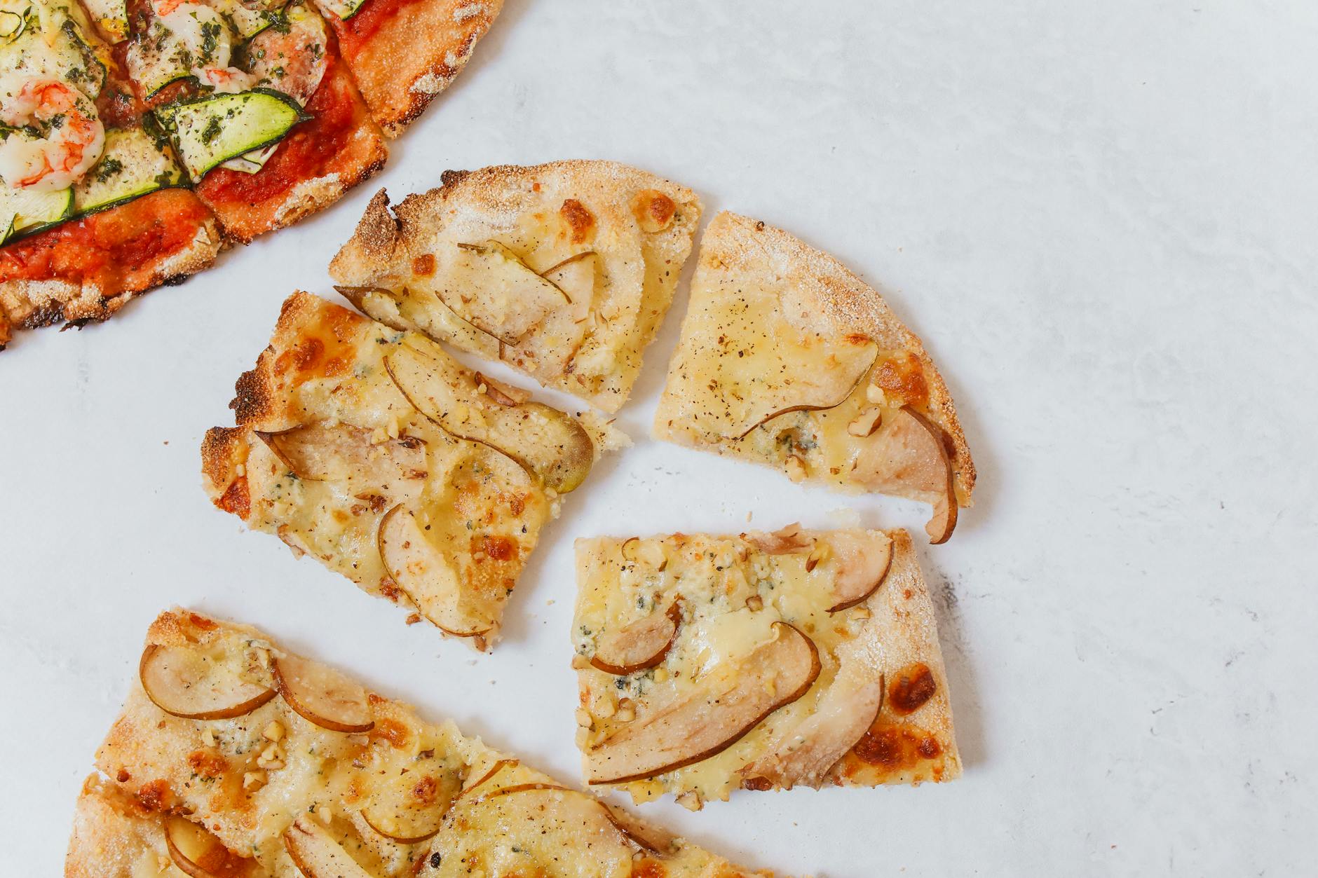Kawałki wykwintnej pizzy z różnymi dodatkami na białym tle