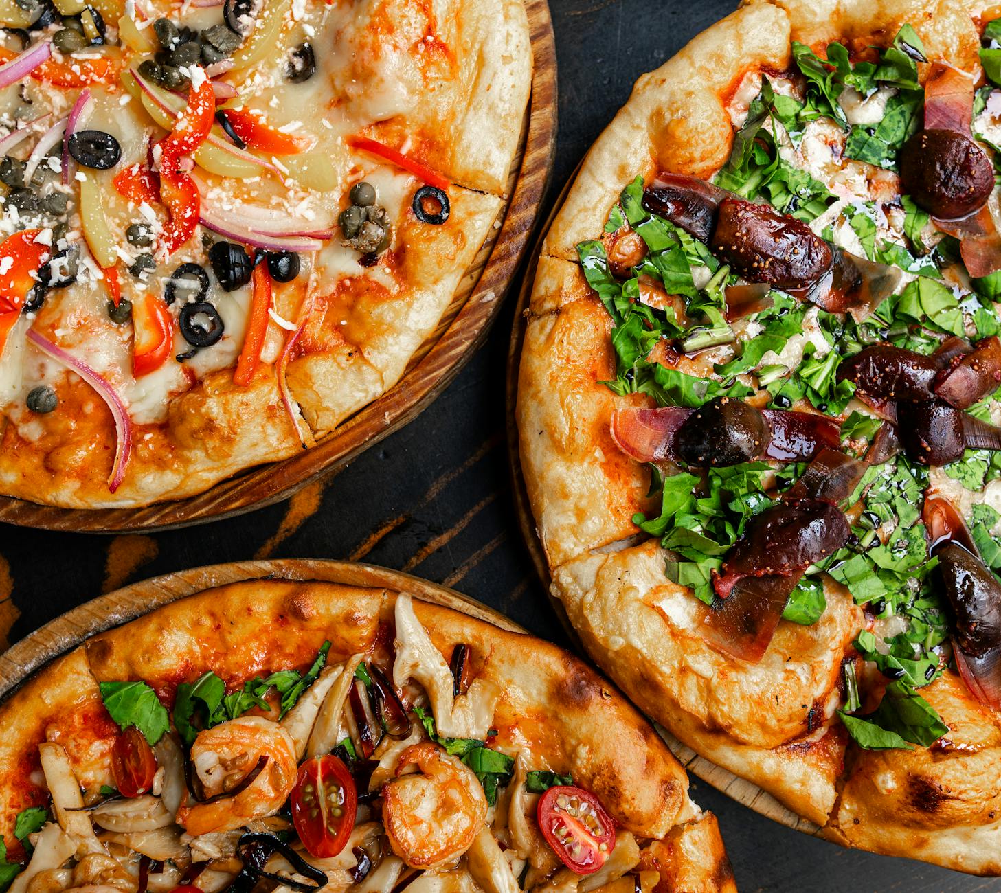 Różne pizze gourmet z świeżymi dodatkami w tętniącej życiem pizzerii