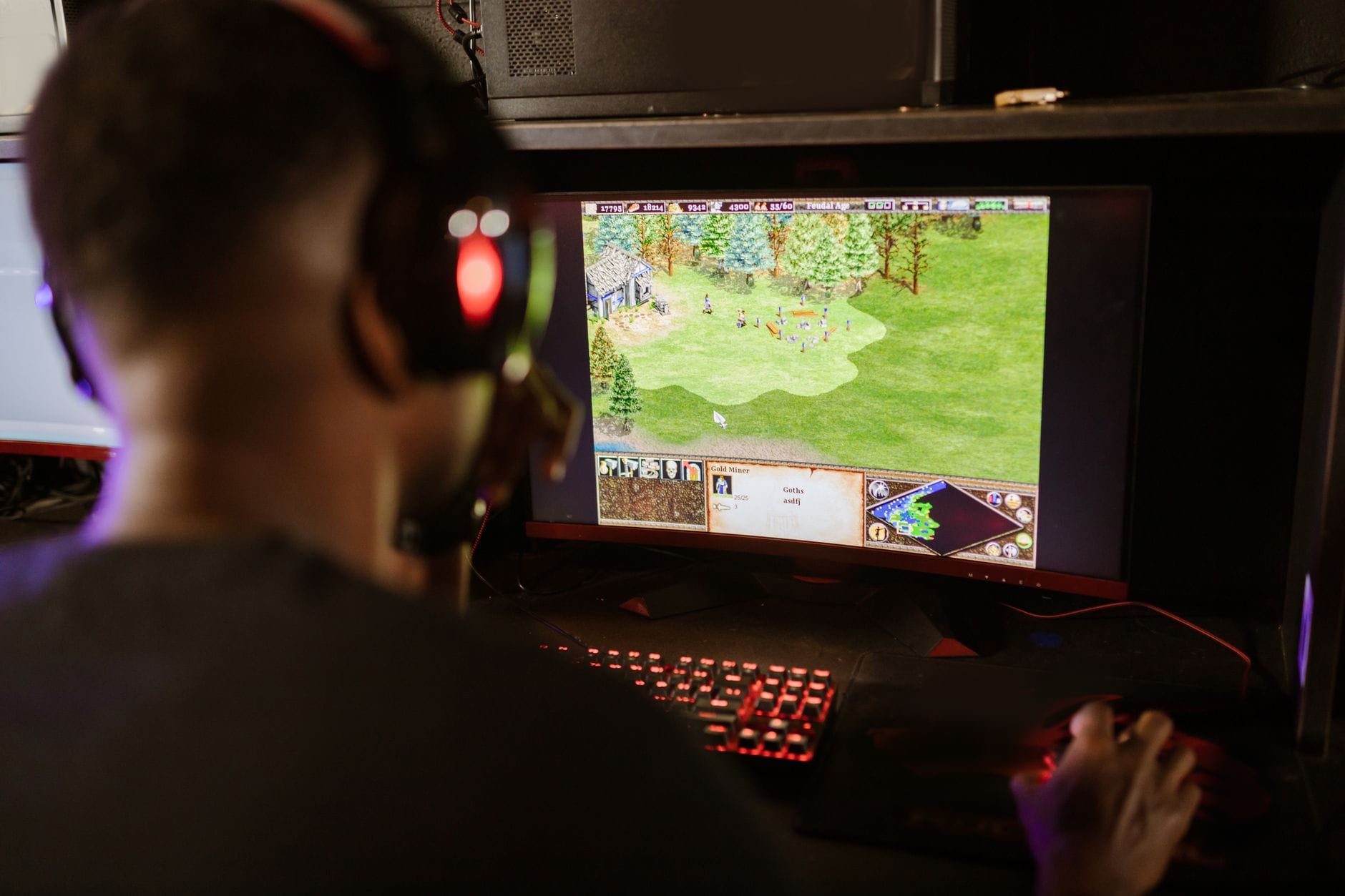 Gracz przy komputerze skupiony na rozgrywce RPG na dużym monitorze