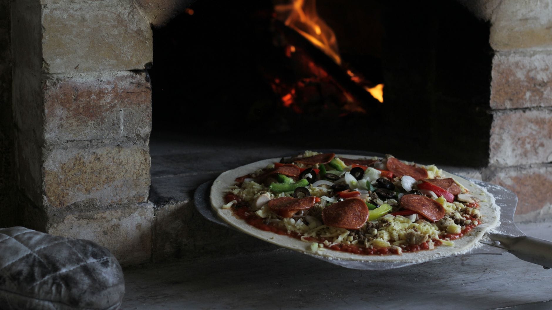 Pizza wypiekana w tradycyjnym kamiennym piecu opalanym drewnem