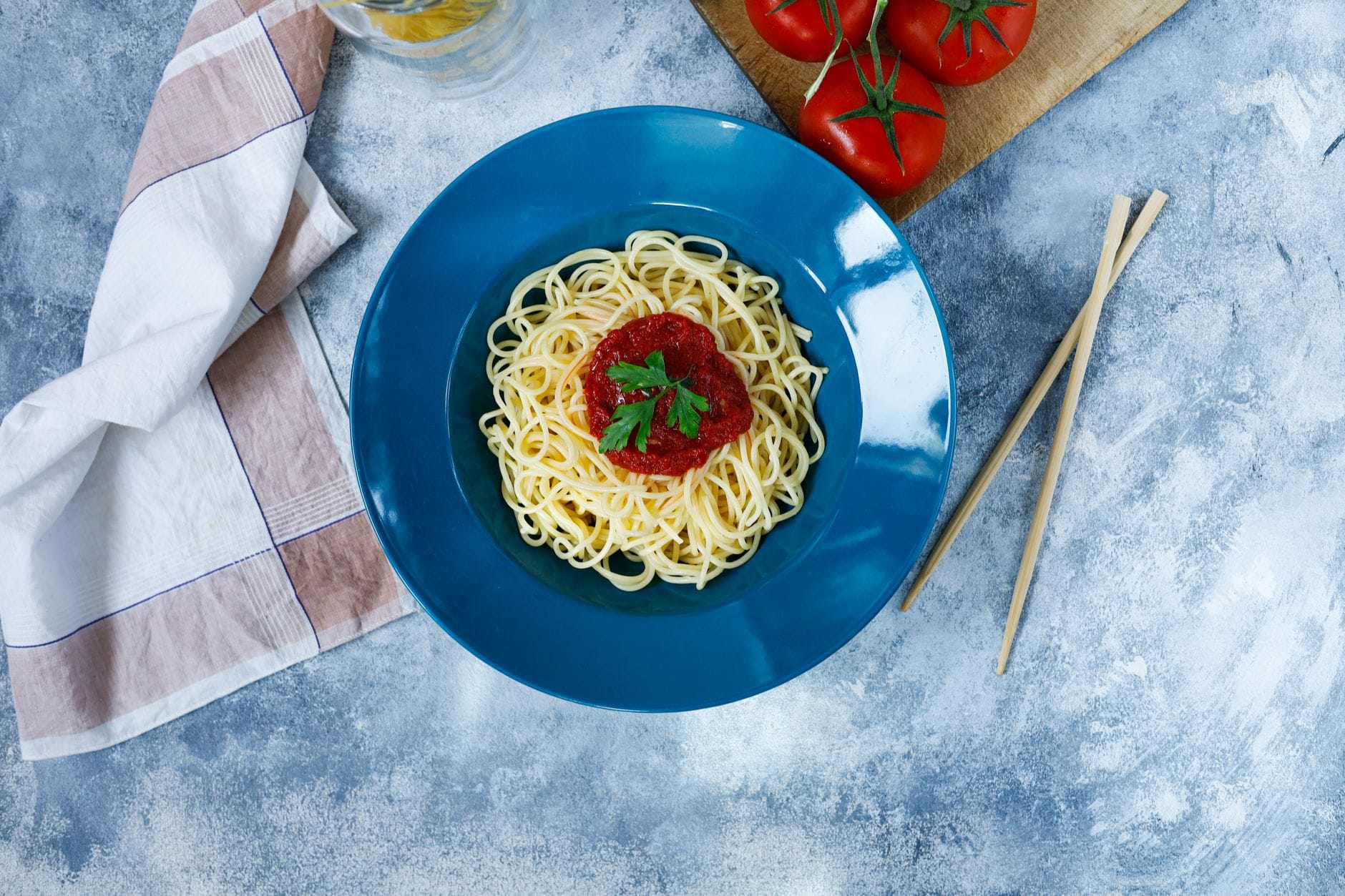 Spaghetti z sosem pomidorowym i pietruszką na niebieskim talerzu z góry